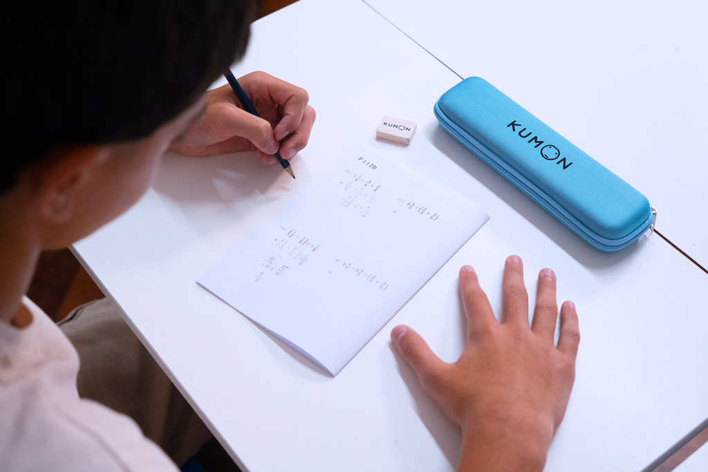 Alumno resolviendo ejercicios avanzados de matemáticas en un cuaderno Kumon, siguiendo un aprendizaje gradual y estructurado-Bolivia