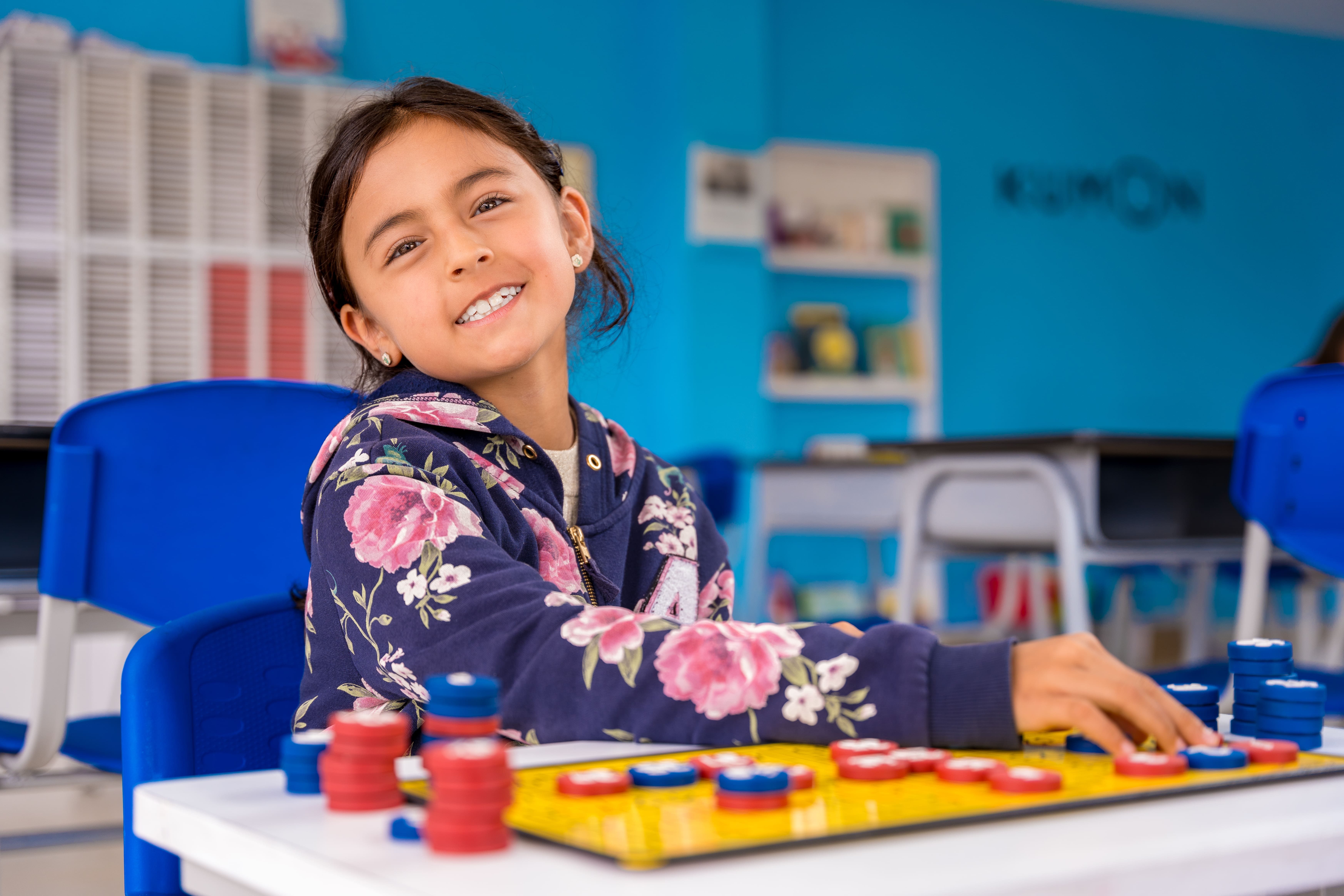 Niña estudiando matemáticas básicas con tablero magnético en un centro Kumon, disfrutando del aprendizaje-Bolivia