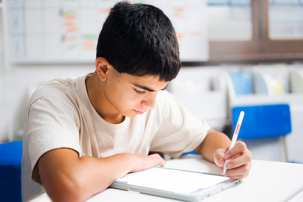 Estudiante concentrada resolviendo ejercicios en papel como parte del método Kumon de estudio individualizado-Bolivia