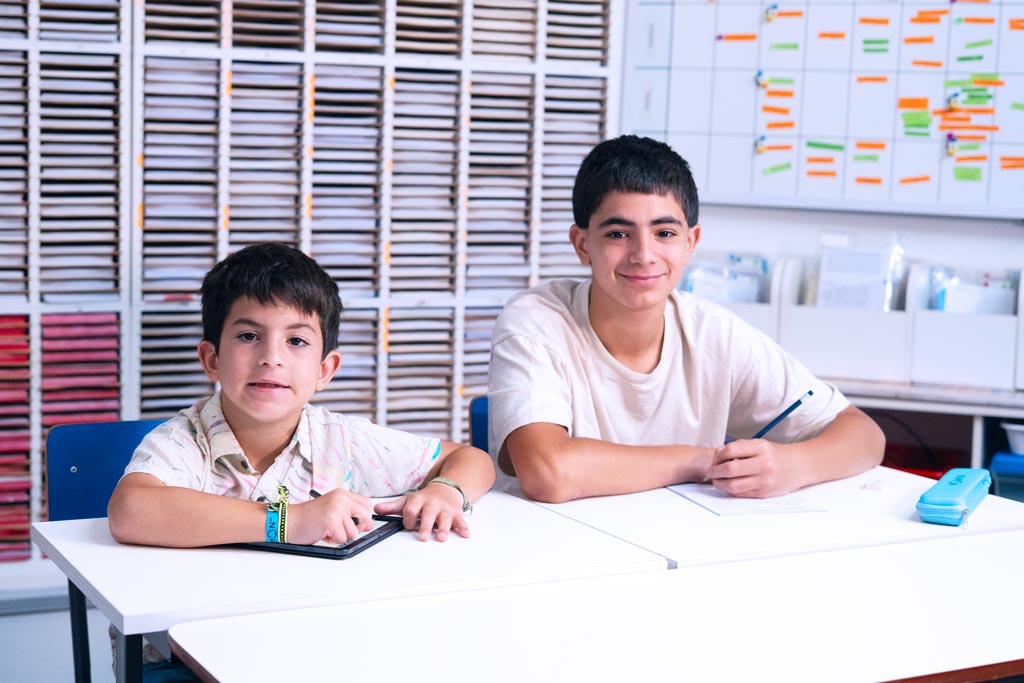 Dos alumnos en un centro Kumon, uno en la tableta y otro en el cuadernillo en papel-Bolivia