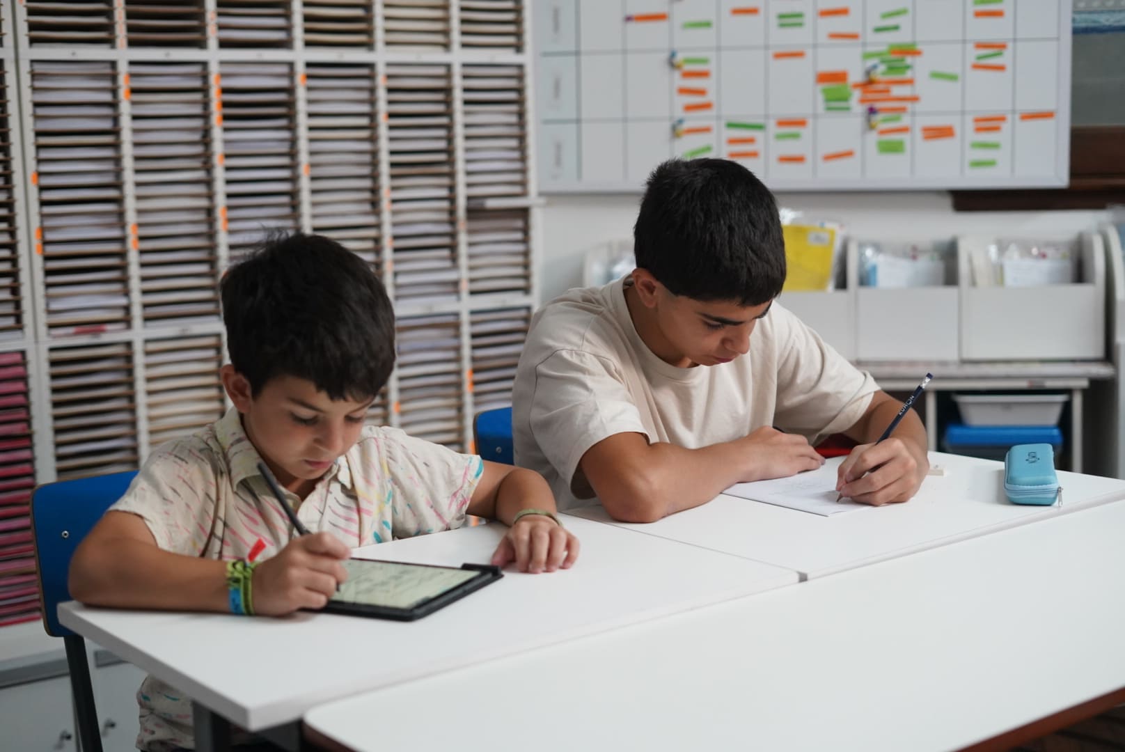 Alumnos haciendo la tarea en el material didáctico, la tablet y el cuadernillo-Bolivia