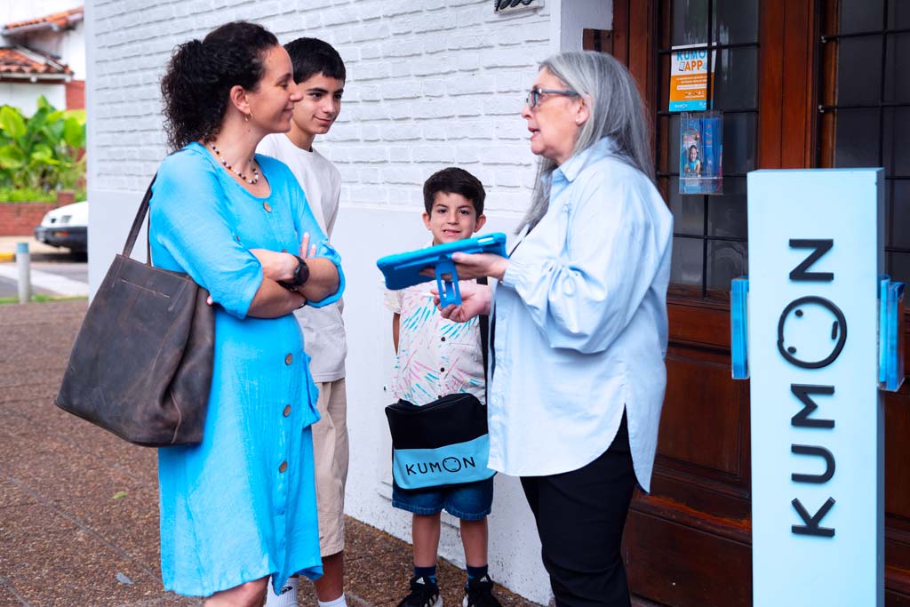 Familia conversando con una orientadora frente a un centro Kumon-Bolivia