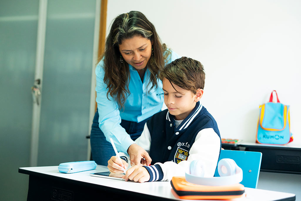 Orientadora de Kumon guiando a um alumno mientras trabaja en tableta-Bolivia